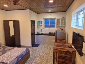 a room with a kitchen with a bed and a table at Sunny Smiles Homestay in Mangalore