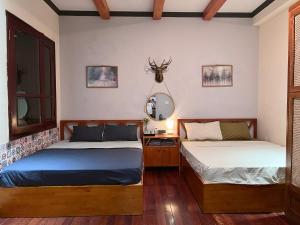 Un dormitorio con dos camas y un espejo. en NGÁO Home - Giảng Võ, en Hanói