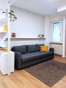 a living room with a black couch and a window at Casa Elio - Appartamento in centro con biciclette in Crema