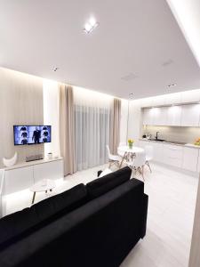 a living room with a black couch and a kitchen at MIA Centrum Wrocław in Wrocław