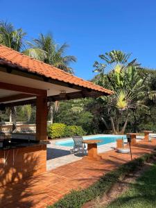 Un patio con una mesa junto a una piscina. en Chalés especiais da Fazenda Itacorá, en Itaipulândia