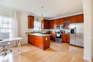 a kitchen with wooden cabinets and stainless steel appliances at Luxurious & Comfy Private Room in DC in Washington