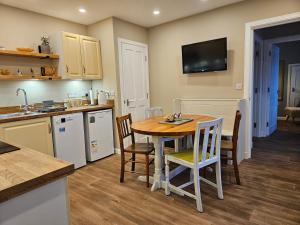 a kitchen with a table and chairs and a kitchen with a television at Binnaquoy in Orkney