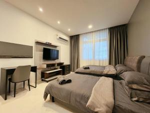 a bedroom with two beds and a desk and a television at Kuching Cozy Comfort 03 - Riverine Diamond Kuching 5 Pax in Kuching +29 photos