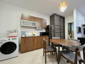 a kitchen and dining room with a table and a dishwasher at Kuching Cozy Comfort 03 - Riverine Diamond Kuching 5 Pax in Kuching