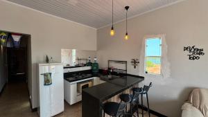a kitchen with a white refrigerator and a counter top at Localize casa na praia in Fortim