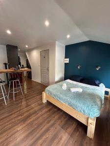 a bedroom with a bed with a blue wall at Studio cosy ambiance vosgienne à 20 mn de Gerardmer in Lépanges-sur-Vologne