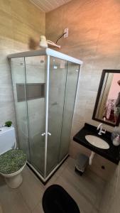 a bathroom with a glass shower and a sink at Localize casa na praia in Fortim