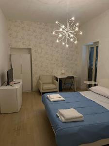 ein Schlafzimmer mit einem blauen Bett und einem Kronleuchter in der Unterkunft RMG Home in Fisciano