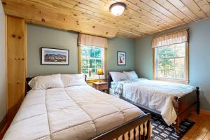 a bedroom with two beds and two windows at Bethel Peak Escape in Bethel
