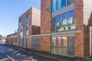 a red brick building with windows on a street at Modern tranquil beach retreat - warm studio with fast links to city centre in Edinburgh
