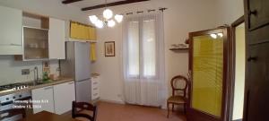 a kitchen with white cabinets and a yellow door at Panigale90 in Bologna