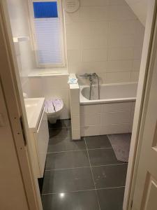 a bathroom with a tub and a sink and a toilet at Apartment DAHL 3 Zimmer in Blankenfelde
