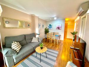 a living room with a couch and a table at LA MER BLEUE, Boutique Apartament with free parking, full equipped in Fenals Beach in Lloret de Mar