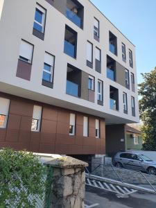 un edificio con un coche aparcado delante en Apartment sPARK Niš, en Niš