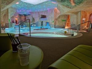 a drink sitting on a table in front of a swimming pool at Privately Owned Apartment in Spa hotel in Pärnu
