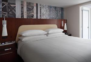 a bedroom with a large bed with white sheets and pillows at Marriott at the University of Dayton in Dayton
