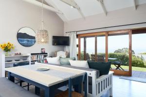 una sala de estar con un sofá y una mesa en HERON COTTAGE - for your seaside holiday., en Chintsa