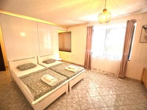 a bedroom with two beds and a large window at Apartman Centar in Posušje