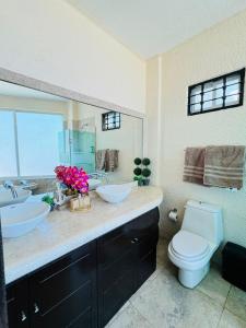 Un baño con dos lavabos y un inodoro. en 3 Atardeceres, Pet Friendly Vista al Mar en Brisas, en Acapulco