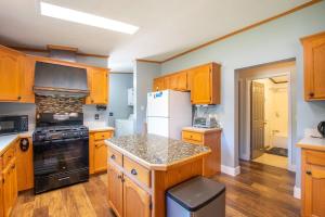 a kitchen with wooden cabinets and a white refrigerator at Spacious Leelanau home near the best of Michigan in Cedar