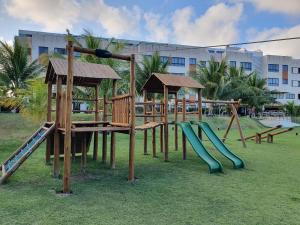 a playground in a park with a slide at Guarajuba Paraíso dos Coqueiros in Guarajuba