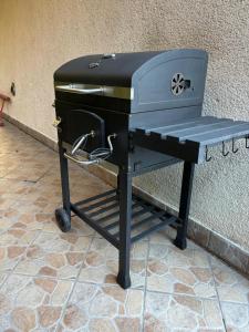 a grill sitting on a stand next to a wall at "Jurkówka" in Szczyrk