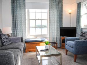 ein Wohnzimmer mit Sofa und Fernseher in der Unterkunft 8b Fore Street in Salcombe