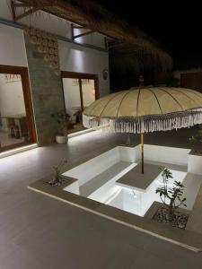 Una habitación con una sombrilla grande en un edificio. en Private Villa - New! Casa Luna Jimbaran 3BR Indonesian - Greek Villa, en Jimbaran