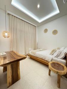 Un dormitorio con una cama y una mesa de madera. en Private Villa - New! Casa Luna Jimbaran 3BR Indonesian - Greek Villa, en Jimbaran 26 fotos más