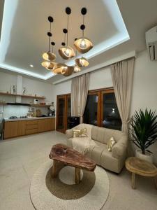 una sala de estar con un sofá y una mesa en Private Villa - New! Casa Luna Jimbaran 3BR Indonesian - Greek Villa, en Jimbaran