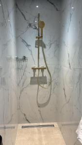 a shower in a bathroom with white marble walls at Cosy 2p in Cagnes-sur-Mer