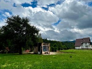 a building in a field next to a house at Tiny Bran in Bran