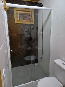 a bathroom with a glass shower with a toilet at Ap a 6km do Aeroporto de Floripa in Florianópolis