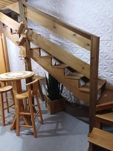 a wooden loft bed with two chairs and a table at Ap a 6km do Aeroporto de Floripa in Florianópolis +20 photos