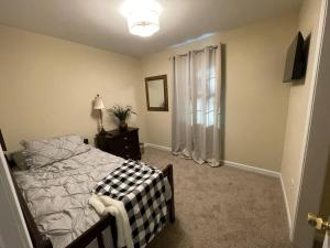 a bedroom with a bed and a dresser and a window at Casa del Lago in Oil City