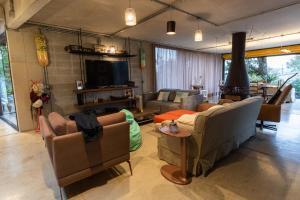 un soggiorno con divani e TV a schermo piatto di Blaze s SkateHouse Eco-spa e Refugio- Atibaia, SP ad Atibaia
