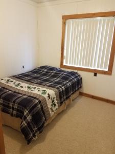 a bedroom with a bed and a window at Lyman's Lagoon Hideaway in Houghton Lake