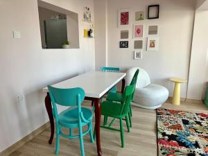 a dining room with a white table and green chairs at ALICE Daire in Konak