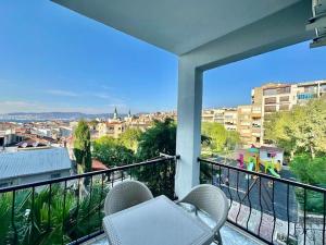 a balcony with two chairs and a view of a city at ALICE Daire in Konak