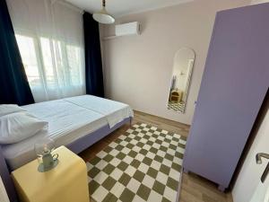 a small bedroom with a bed and a checkerboard floor at ALICE Daire in Konak