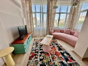 a living room with a pink couch and a tv at ALICE Daire in Konak