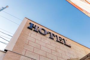 a hogan sign on the side of a brick building at BEX SUENO HOTEL in Samarkand