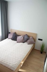 a bed with purple pillows on it in a room at Suur-Posti Apartments in Pärnu