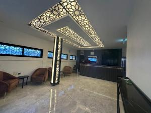 a room with chairs and a large ceiling with a room with a table at Airport INN Hotel in Lomé
