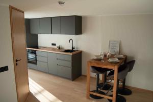 a small kitchen with a wooden table and a sink at Suur-Posti Apartments in Pärnu