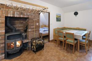 a living room with a brick fireplace and a dining table at Penzion Skála in Čenkovice