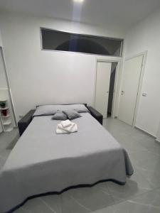 una camera da letto con un letto e un asciugamano sopra di Le 3 Sorelle House a Napoli Altre 19 foto