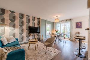 a living room with a couch and a dining room at Agapé by Kleidos -Disney à 10min, T2 , 4P, Parking gratuit et terrasse in Magny-le-Hongre