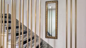un espejo en una pared junto a una escalera en Dreams Almería Center, en Almería